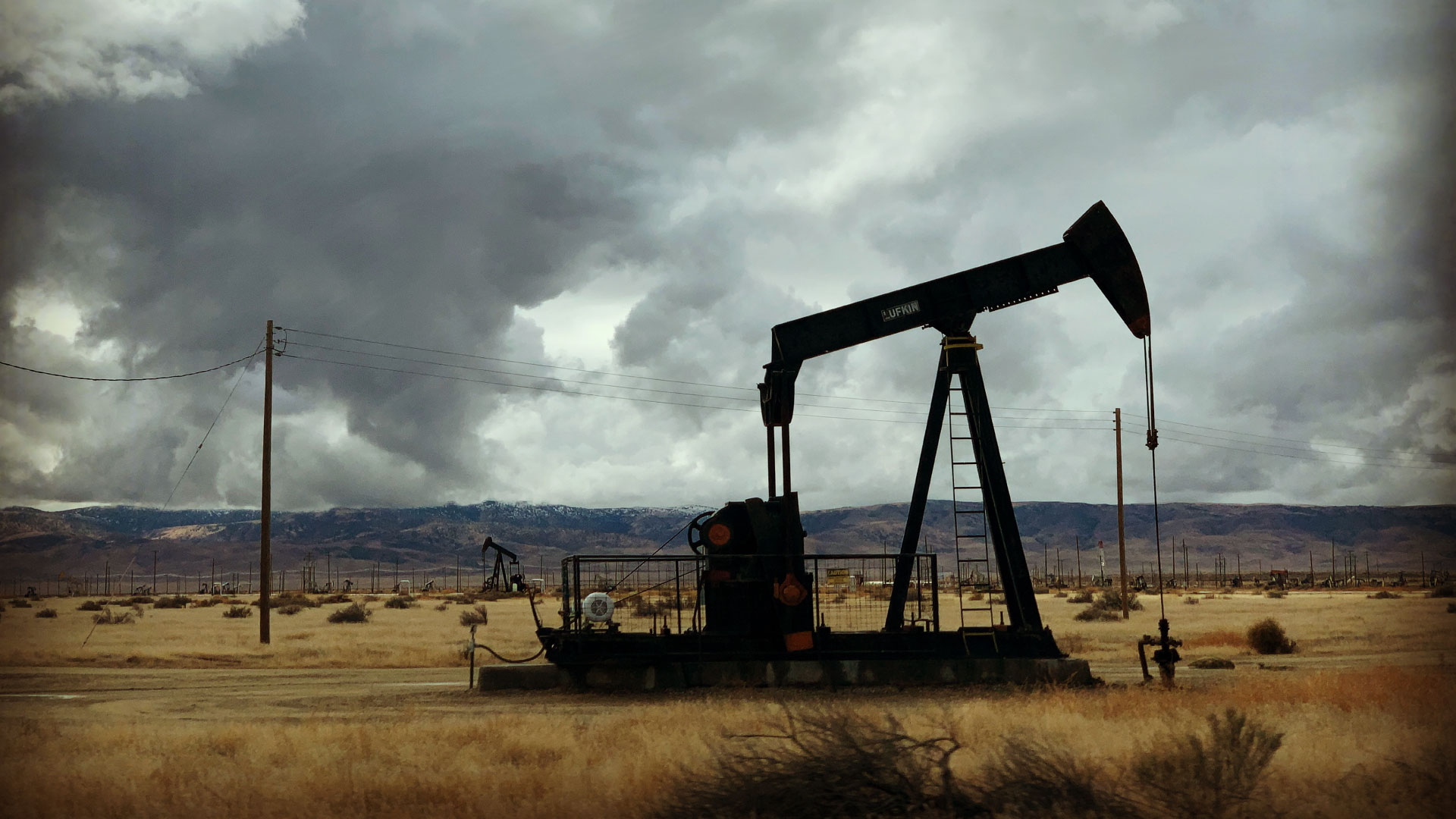 Oil rig on landscape with ominous clouds