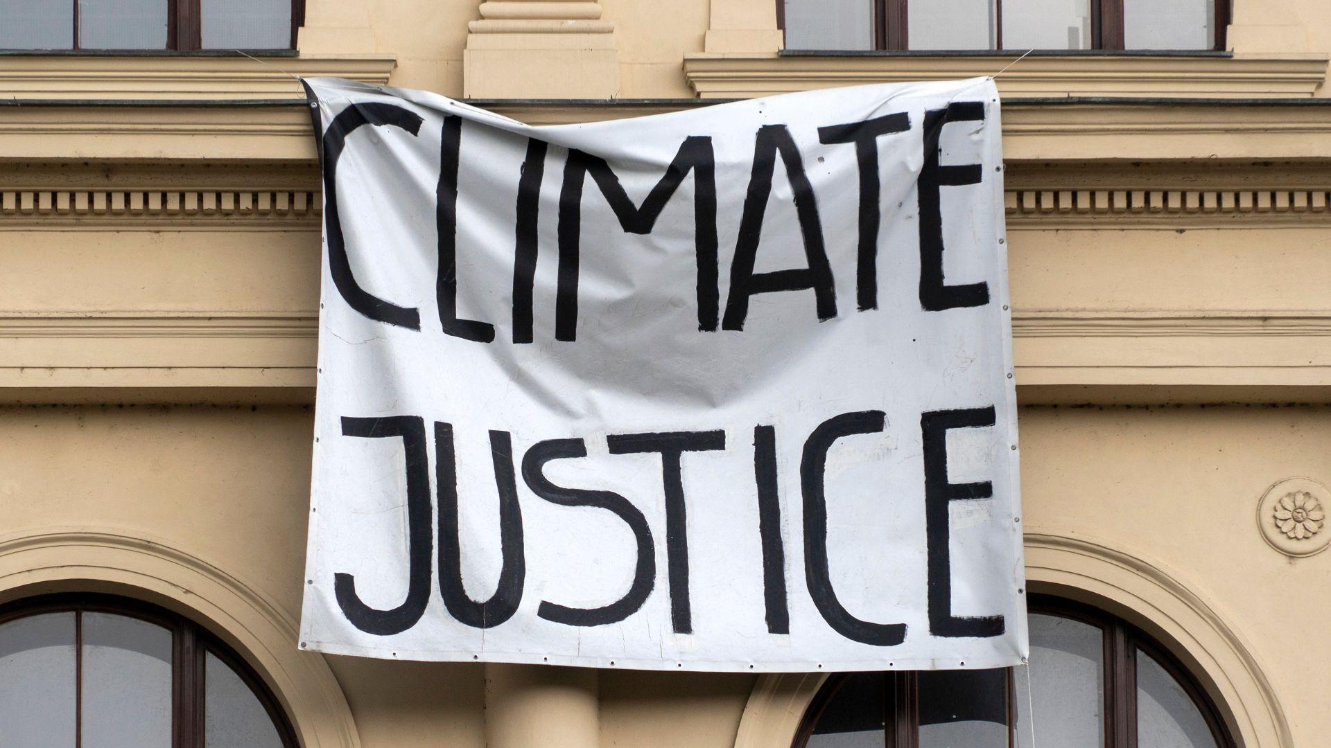 A banner hanging on the side of a building reads "Climate Justice."